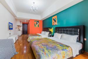 广州薰衣草之家（番禺万达/万博中心热门商圈）的橙色和蓝色墙壁的客房内的两张床