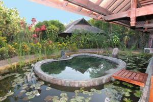 佩母德兰蓬杜萨里海滩及Spa度假酒店的花园内带长凳的锦 ⁇ 池塘