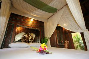 佩母德兰蓬杜萨里海滩及Spa度假酒店的一张带华盖的床,上面有花