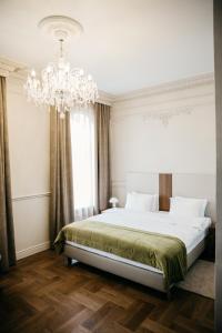 伊尔库茨克Hotel Amurskiy的一间卧室配有一张大床和一个吊灯。