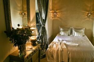 马拉喀什格尔法美庭院旅馆的卧室配有白色的床和镜子