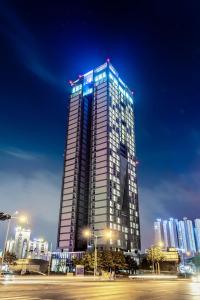 清州市J One Hotel Cheongju的一座高大的建筑,晚上有灯