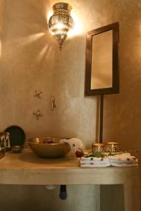 马拉喀什格尔法美庭院旅馆的梳妆台,配有镜子和桌上的碗