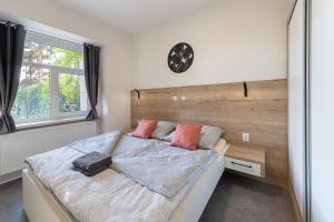 比尔森Apartsee Wellness Plzeň的卧室配有一张床,墙上挂着一个钟