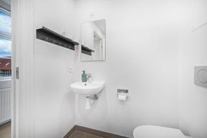 欧登塞Kragsbjerggaard的白色的浴室设有水槽和卫生间。