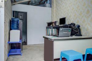 巴东OYO 3266 Alifah Residence Syariah的办公室配有带笔记本电脑和椅子的书桌