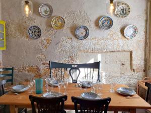 马翁Sant Roc的墙上一张带椅子和盘子的木桌