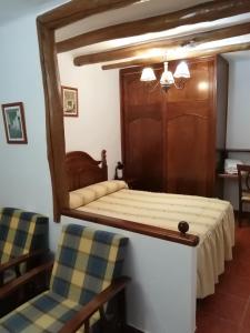 卡皮雷拉hostal ruta de las nieves的一间卧室配有一张带镜子的床和两把椅子