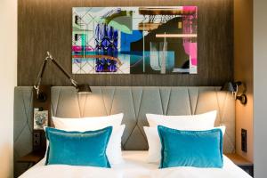 柏林柏林哈克市场一号汽车旅馆的配有蓝色枕头的床的酒店客房
