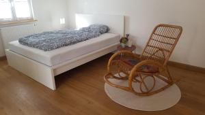德根多夫Ferienwohnung Zellner的一间卧室配有一张床和一把摇椅