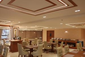 艾哈迈达巴德SK Lords Eco Inn Ahmedabad的一间在房间内配有桌椅的餐厅