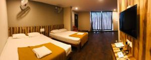 SomvārpetSharada Residency的酒店客房设有两张床和一台平面电视。