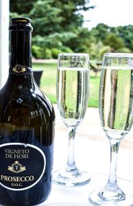 特伦特河畔伯顿德威克利夫豪尔酒店的一瓶香槟和一张桌子上的两杯酒