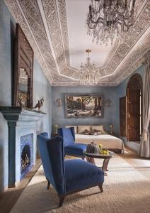 马拉喀什马拉喀什苏丹娜世界小型豪华酒店的一间蓝色卧室,配有一张床和一个吊灯