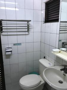 台南光华大饭店的白色的浴室设有卫生间和水槽。
