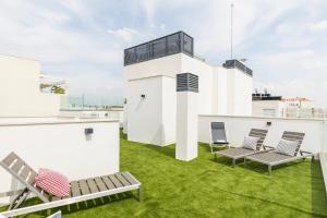 马德里Feelathome Goya Apartments的屋顶上带椅子和草地的天井