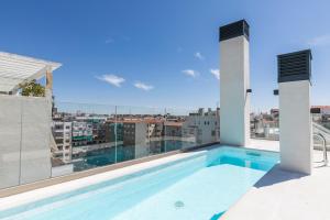 马德里Feelathome Goya Apartments的建筑物屋顶上的游泳池