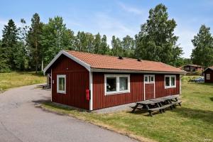 法伦First Camp Lugnet-Falun的红色的棚子,配有野餐桌和长凳
