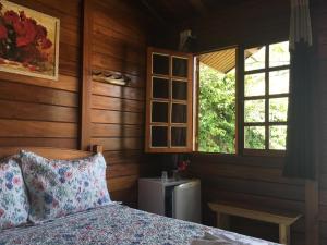 蒙特韦尔迪Chalés Eucaliptos的一间卧室设有床、两个窗户和散热器