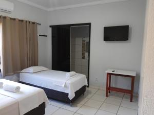 帕尔马斯Pousada Braga的酒店客房设有两张床和电视。