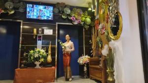 Ban Bang BamruSUDYOD HOTEL的站在镜子前抱着鲜花的女人
