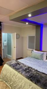 约翰内斯堡Made Guest House的一间卧室配有一张蓝色的大床
