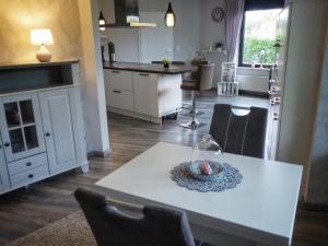 腓特烈罗达Dorfidylle - Thüringer Wald Rennsteig的厨房以及带白色桌椅的起居室。