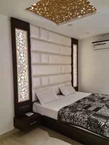 GangānagarHotel Star Inn的一间卧室设有一张床和两个窗户。