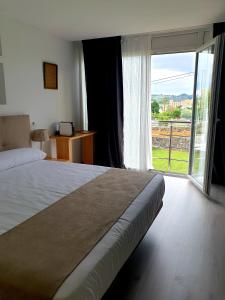 蒙帕亚Hotel Finca Alcamino的一间卧室设有一张大床和一个大窗户
