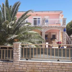 维尔DosPalmeras的粉红色的房子,有栅栏和棕榈树
