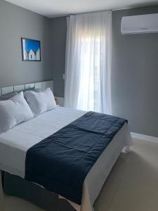 卡波布里奥Flat Edifício Royale 305的一间卧室设有一张大床和一个窗户。