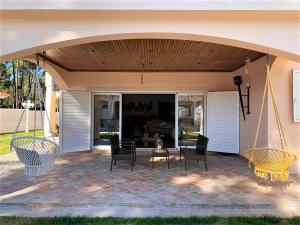 克洛伊奥斯Moradia Pinhal da Telha的庭院设有遮阳篷、椅子和桌子