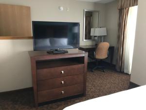 圣克劳德Holiday Inn Express and Suites St. Cloud, an IHG Hotel的饭店房间梳妆台上的电视