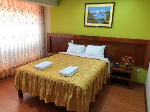 塔克纳Sumaq Hotel Tacna的一间卧室配有一张床,上面有两条毛巾