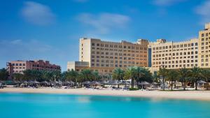 多哈InterContinental Doha Beach & Spa, an IHG Hotel的从海滩上欣赏到宫殿酒店的景色