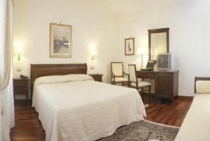 梅斯特克丽斯皮别墅酒店的一间卧室配有一张床、一张书桌和一台电视