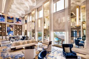 多哈InterContinental Doha Beach & Spa, an IHG Hotel的大堂配有沙发、椅子和窗户。