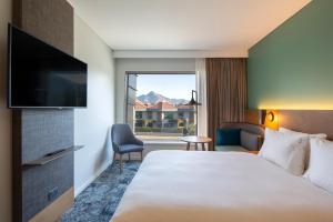 皇后镇Holiday Inn Express & Suites Queenstown, an IHG Hotel的配有一张床和一台平面电视的酒店客房