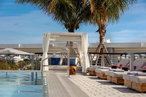 迈阿密海滩Kimpton - Hotel Palomar South Beach, an IHG Hotel的游泳池旁带躺椅的游泳池