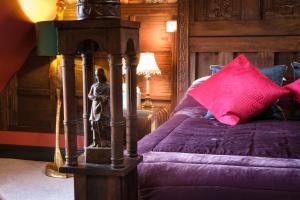 滨海索尔特本Brockley Hall Hotel的一间卧室配有一张带紫色床单和粉色枕头的床。