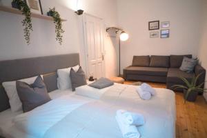 因斯布鲁克Cosy and Spacious Apartment in the heart of Innsbruck的客厅配有一张大白色的床,配有沙发