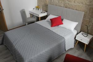 布朗库堡Alojamento Girassol的一间卧室配有一张红色枕头的床