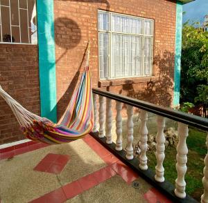 埃尔科莱希奥Villa Claudia - apartamento cómodo y tranquilo的吊床坐在房子的阳台上