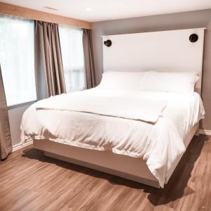 卡尔加里Along River Ridge的一间卧室配有一张带白色床单的大床