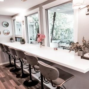 卡尔加里Along River Ridge的厨房配有大型白色台面和椅子
