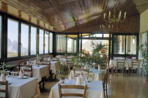 埃维萨埃特恩酒店的餐厅设有白色的桌椅和窗户。