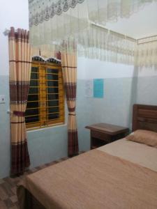 Kon TumHomestay Nang Nghieng的一间卧室配有床和带窗帘的窗户