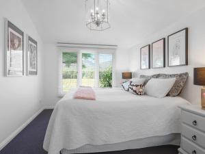 BulgaMeerea Country Estate adjoining Wollombi National Park的白色的卧室设有一张大床和一个窗户
