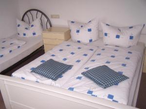 伯根Hotel-Pension Sandl的一间卧室配有两张带蓝白色床单和枕头的床。
