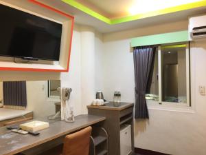 斗六市微旅时尚旅店的一间墙上配有电视和书桌的房间
